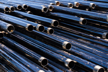 Pipe for Drilling rigs for oil and gas on background. Drilling of oil and gas wells. Drill pipe. Tubing for oil and gas listed on the pedestal out of the wells after washing and ready for inspection