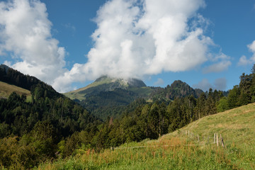 Swiss field and a view on Le Moleson in the clouds, Switzerland 