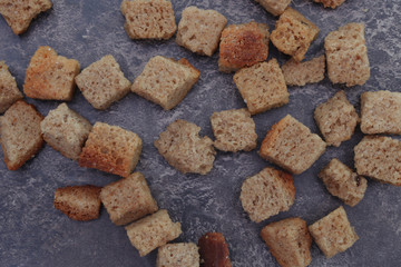 Croutons on a brown background close-up. Pieces of toasted bread. Ingredient
