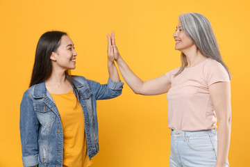 Smiling cheerful family asian women girls gray-haired mother and brunette daughter in casual...
