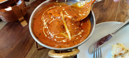 Indian food including curries, spice sauce and naan bread.