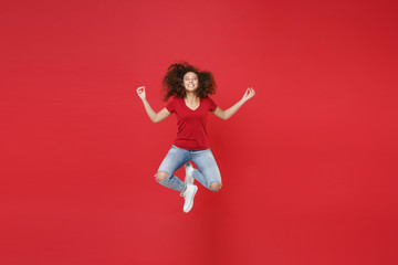 Full length portrait smiling african american girl in casual t-shirt isolated on red background. People lifestyle concept. Jumping hold hands in yoga gesture, relaxing meditating, trying to calm down.