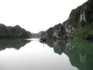 Fototapeta na wymiar Halong Bay. with Limestone Cliffs and Boat Reflected in Water, Vietnam