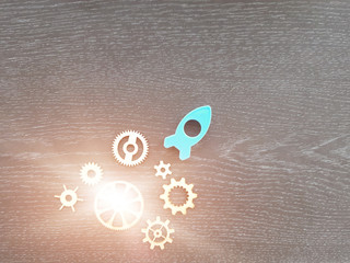 A blue rocket pointing up, wooden gears on a dark background. The concept of striving up, leadership.