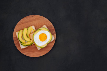 Healthy brekfast toasts with avocado on the black stone background flat lay mock-up with copy space