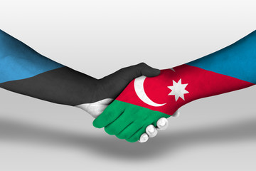 Handshake between azerbaijan and estonia flags painted on hands, illustration with clipping path.