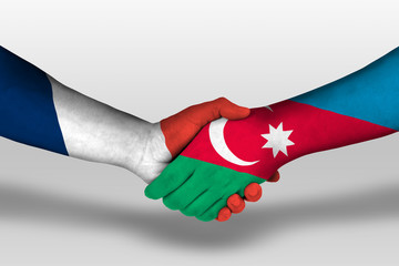 Handshake between azerbaijan and france flags painted on hands, illustration with clipping path.