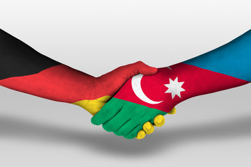 Handshake between azerbaijan and germany flags painted on hands, illustration with clipping path.