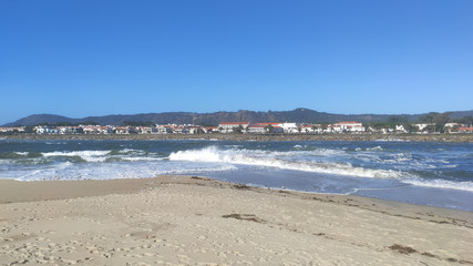 Waves of water of the river and the sea meet each other during high tide and low tide. Whirlpools of the Cavado River in Esposende, Portugal.