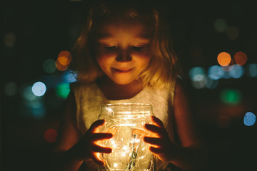 Young toddler girl holding magic fairy lights
