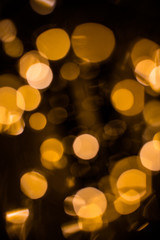 Golden bright glow bokeh. Christmas vintage lights on black background. Colorful blurred abstract defocused