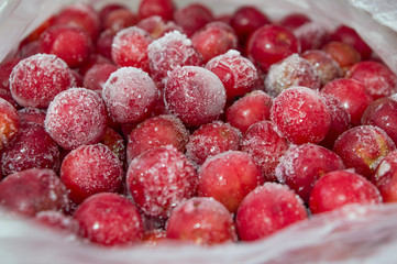 Frozen red berries in a plastic bag. Frozen red cherries. Frost-covered cherries. Red cherry.
