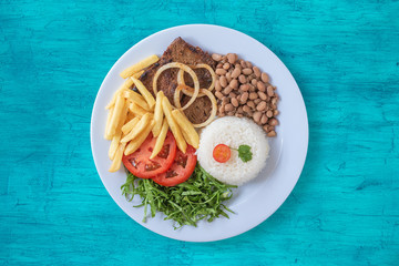 Brazilian food dish. Beans, rice, meat, chips, cabbage, tomatoes, onions. Executive dish. Dish...