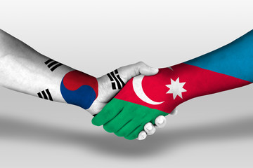 Handshake between azerbaijan and south korea flags painted on hands, illustration with clipping path.