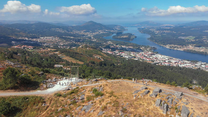 Fototapeta na wymiar Aerial view of the CerLove giant wooden swing in Vila Nova de Cerveira, Portugal. The swing of the valley of Minho is next to the viewpoint of of Cervo. People on swings admire the view.