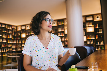 Young woman with cup of tea in cafe