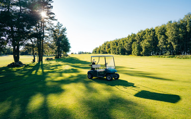 Golf cart or golf club cars in a beautiful golf course. Green golf and light of sun to beauty view...