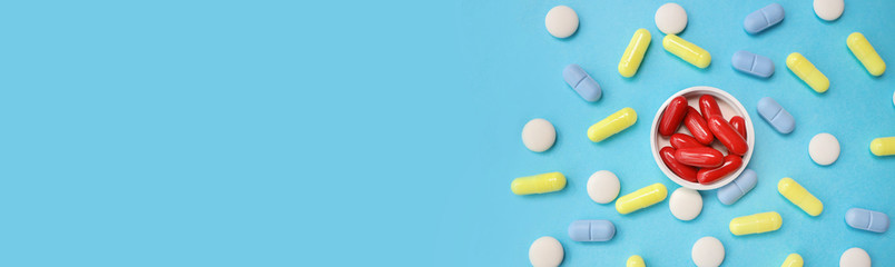 red pills on a white cover, blue, yellow pills, blue background.Baner, place for text on the left side