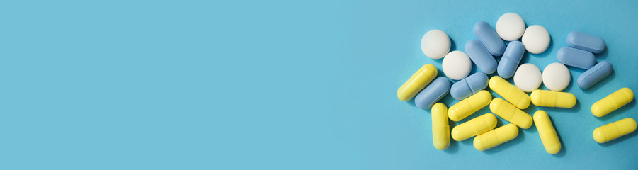pills on a blue background, multicolored pills. with place for text from the left. banner