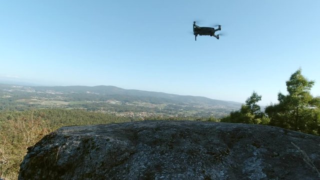 view of the drone landing on a rock against the backdrop of a beautiful natural mountain landscape