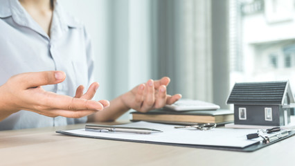 The real estate agent explains the business contract, rent, purchase, mortgage, a loan, or home insurance to the women buyer