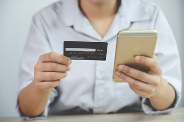 Businessman hand hold credit card to online shopping on smartphone from home, payment e-commerce,...