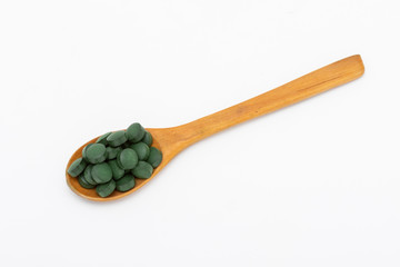 Wooden spoon with green pills
