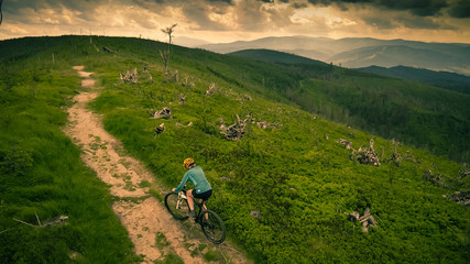 Fototapeta na wymiar Cycling woman riding on bike in autumn mountains forest landscape. Woman cycling MTB flow trail track. Outdoor sport activity.