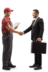 Fototapeta premium Full length profile shot of a contractor worker shaking hands with a businessman