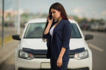 beautiful young woman with phone near car