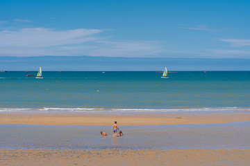 Obraz premium Arromanches, France - 08 04 2020: Children playing in the sea water