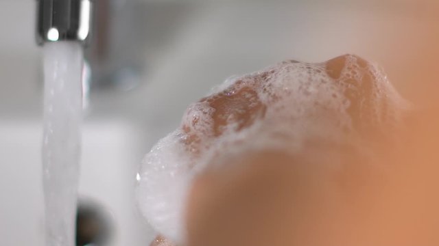 Slow motion of woman washing the hands with soap in the sink of the bathroom during Covid-19 pandemic to disinfect and eliminate germs and viruses. Hygiene, personale care, safe.