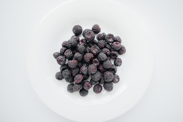 Black raspberry berries close-up on a white background. Healthy food, natural vitamins. Fresh berries