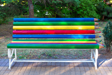 bright bench with pencil-shaped planks. A place to relax in the park.