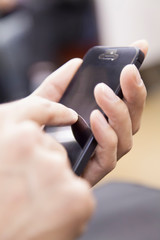 電車でスマホをする男性