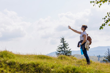 Fototapeta premium Woman tourist photographs on the phone .