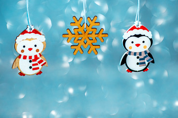 wooden decorations for a Christmas tree penguin and a snowman on a blue background