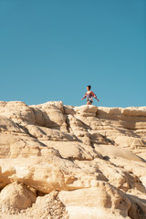 Mujer caminando  sobre una duna fosilizada en la costa de Cabo de Gata en Almeria bajo el sol de...