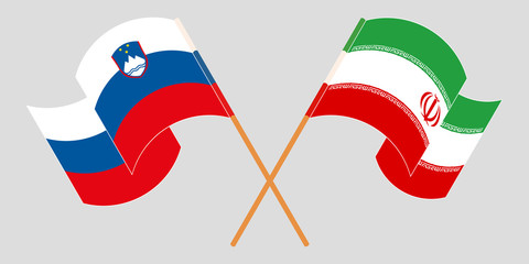 Crossed and waving flags of Iran and Slovenia