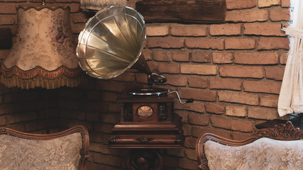 Antique music device vinyl record player old vintage gramophone with horn in elegant retro living room