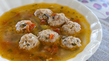 Close up plate with traditional romanian meatballs soup (ciorba de perisoare)