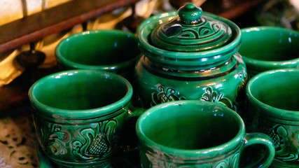 Close up view of colorful artisanal ceramic tea cups and teapot pottery handcrafted