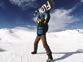 Fototapeta Snowboardzista triumfujący z deską ponad głową na stoku we francuskich Alpach  obraz