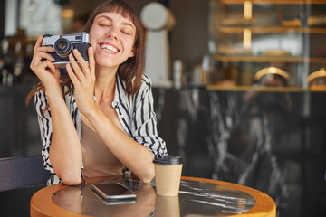  Happy female photographer who holding her camera and enjoying her work