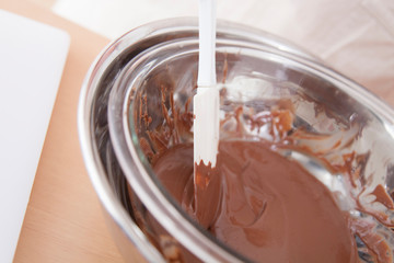 チョコレートを溶かす女性の手元