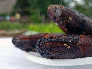 Smoked bream on a white plastic plate. Golden smoked fish close up top view. Hot smoked fish. Food photo. 