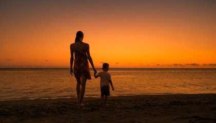 Mother and child going for a walk down the beach. 