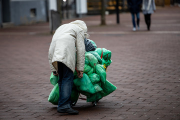 poor old woman carrying garbage in streets of Germany