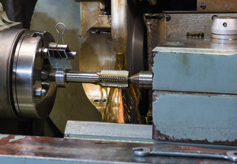 The sharpener is working. Part sharpening in oil and sparks. Very beautiful