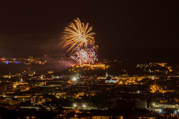 Fireworks over the night city of Brno in the Czech Republic in Europe. Above the city are different colored shapes of flares.